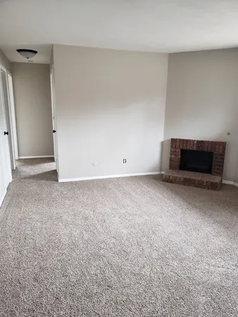a view of an empty room with a fireplace