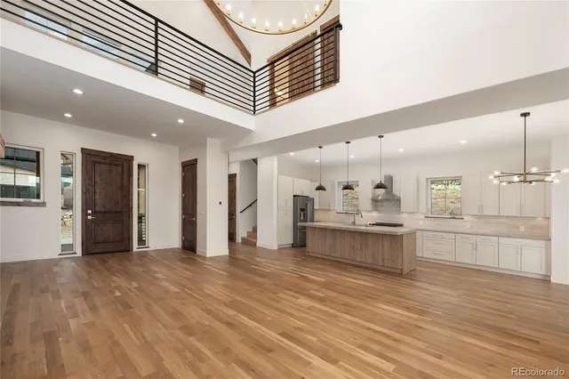 a large white kitchen with kitchen island a sink stainless steel appliances and cabinets