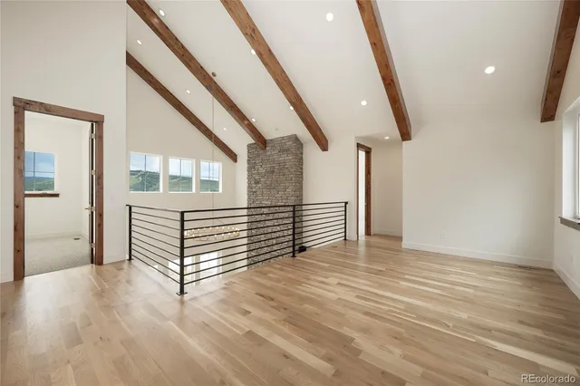 a view of a hallway with wooden floor and white walls