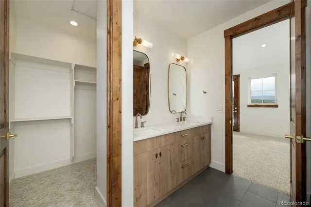 a en suite bathroom with a double vanity sink a mirror and a shower