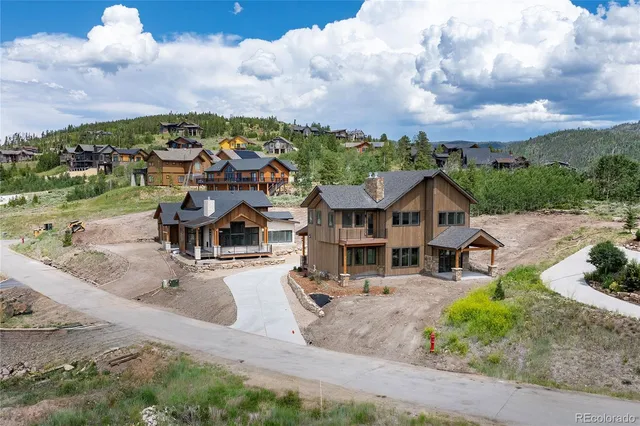 an aerial view of residential houses with outdoor space and trees