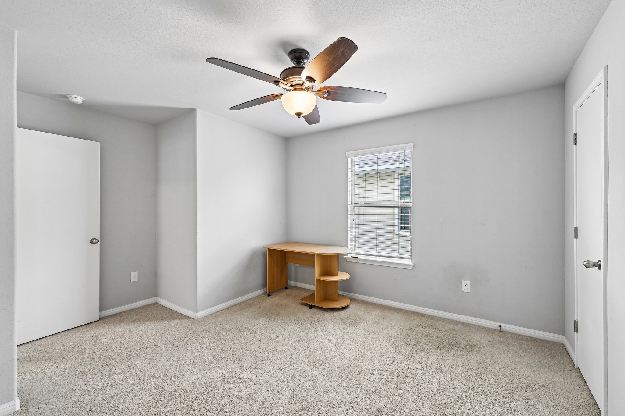 387 Guemal Road Buda, TX 78610 - Photo 21 of 39 Carpeted interior room featuring a ceiling fan with integrated lighting, a window with horizontal blinds, and light gray walls with white trim