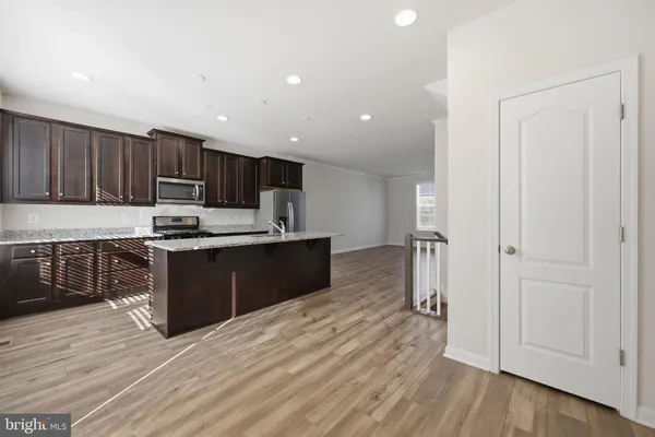 a kitchen with stainless steel appliances granite countertop a refrigerator and a stove top oven
