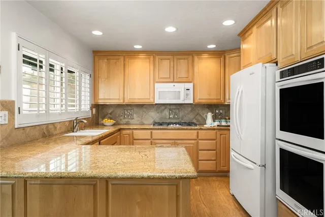 a kitchen with granite countertop cabinets stainless steel appliances a sink and a window