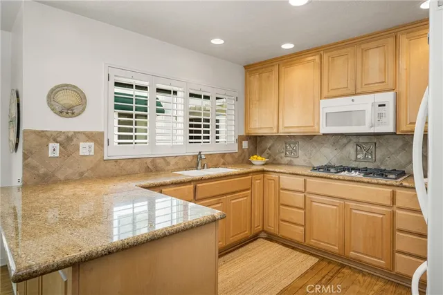 a kitchen with granite countertop a sink and a stove