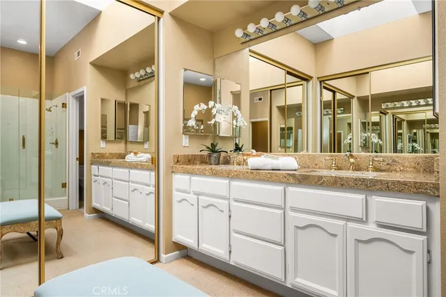 a spacious bathroom with a granite countertop sink mirror and shower