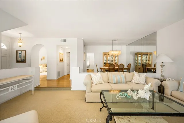 a living room with furniture and a chandelier