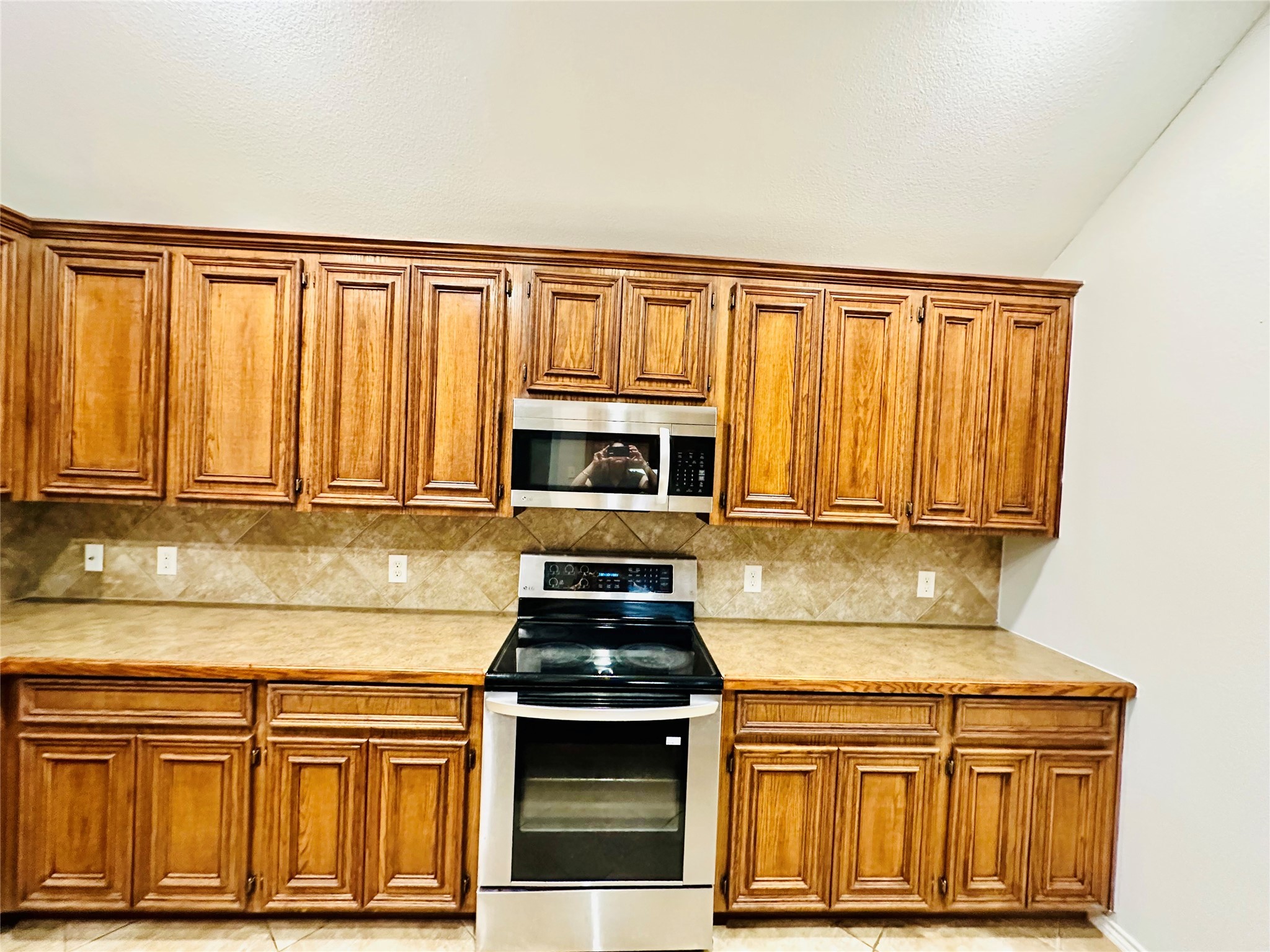 5643 Walnut Glen Lane Rosenberg, TX 77471 - Photo 28 of 35 a kitchen with stainless steel appliances granite countertop a stove a sink and a microwave