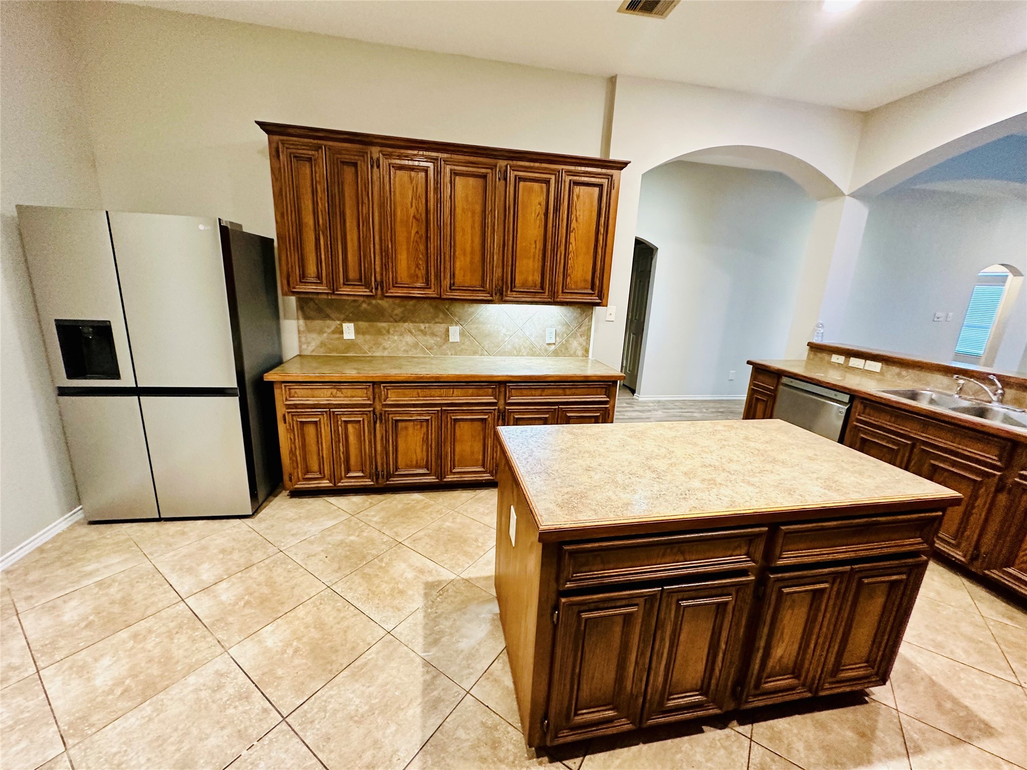5643 Walnut Glen Lane Rosenberg, TX 77471 - Photo 29 of 35 a kitchen with stainless steel appliances kitchen island a stove a sink dishwasher and cabinets