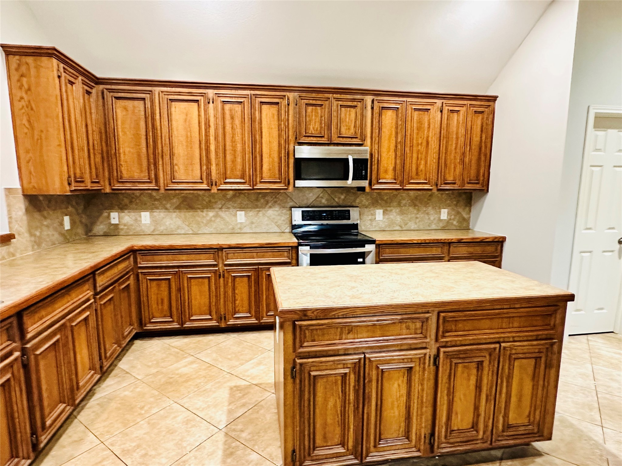 5643 Walnut Glen Lane Rosenberg, TX 77471 - Photo 30 of 35 a kitchen with stainless steel appliances granite countertop a stove top oven a sink dishwasher and a microwave oven with cabinets