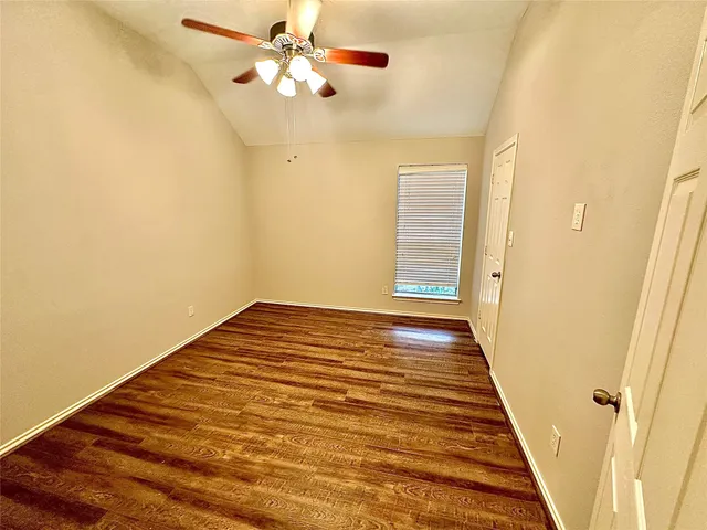 a view of a room with wooden floor and ceiling fan