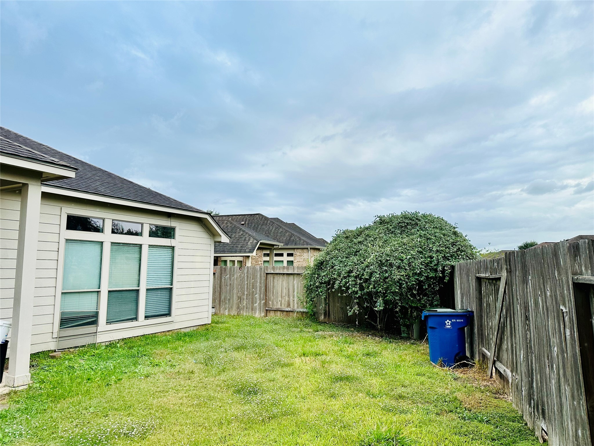 5643 Walnut Glen Lane Rosenberg, TX 77471 - Photo 4 of 35 a view of a backyard with potted plants and a large tree
