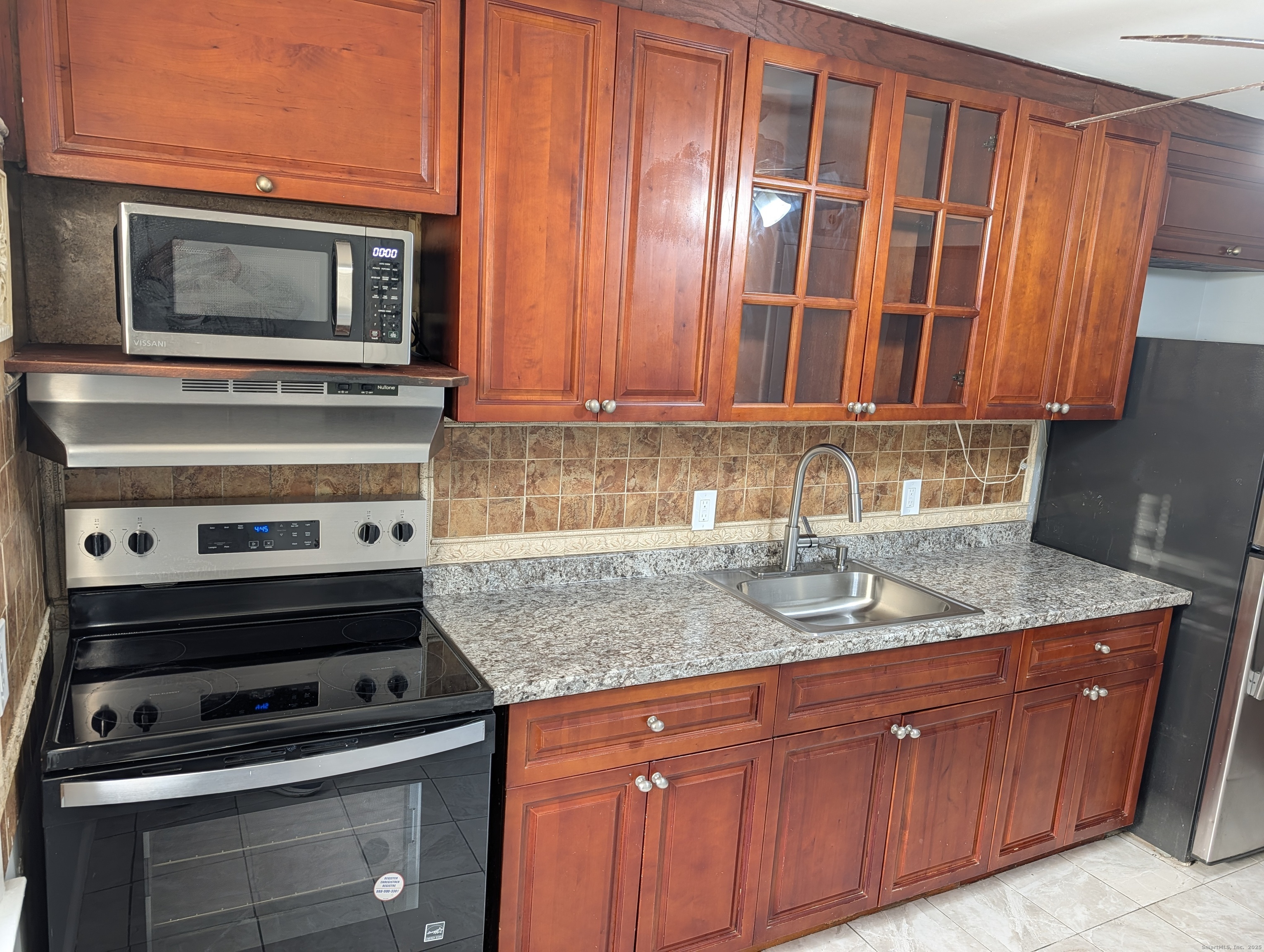161 West Spring Street, Unit B2 West Haven, CT 06516 - Photo 5 of 17 a kitchen with granite countertop a stove top oven cabinetry a sink and dishwasher
