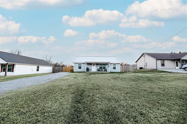 a view of a big house with a big yard and large trees