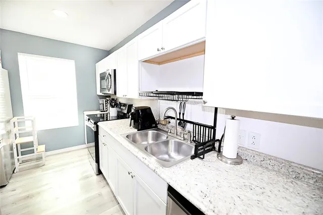 a kitchen with a stove a sink and a refrigerator