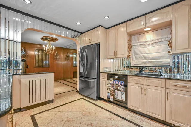 a kitchen with stainless steel appliances granite countertop a refrigerator and a sink
