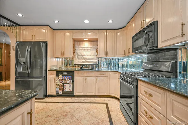 a kitchen with stainless steel appliances granite countertop a refrigerator a stove and a sink