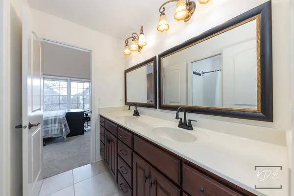 a en suite bathroom with a double vanity sink and a mirror