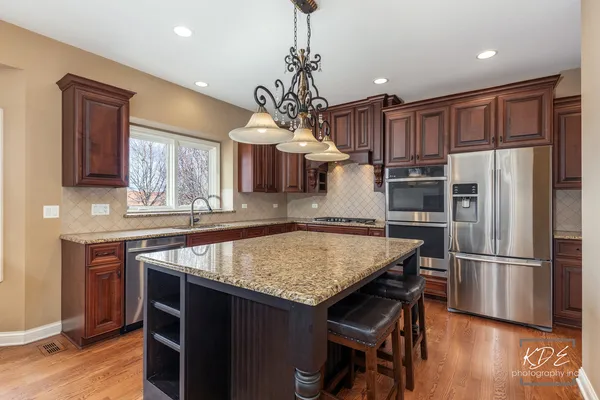 a kitchen with refrigerator cabinets dining table and chairs