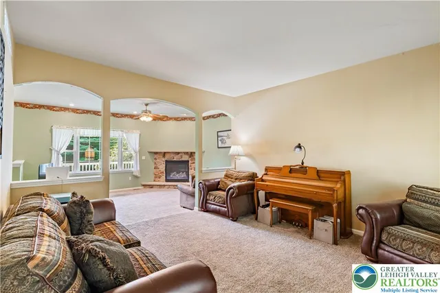 a living room with furniture a fireplace and a large window