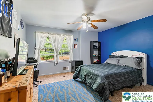 a bedroom with a large bed and a flat tv screen