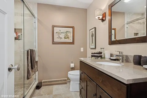 a bathroom with a granite countertop sink toilet and shower