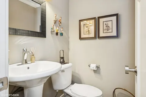 a bathroom with a toilet a sink and mirror