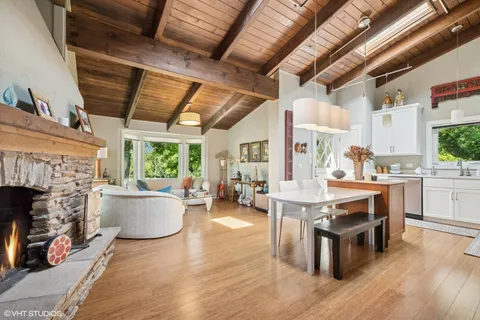 a living room with fireplace furniture and a large window