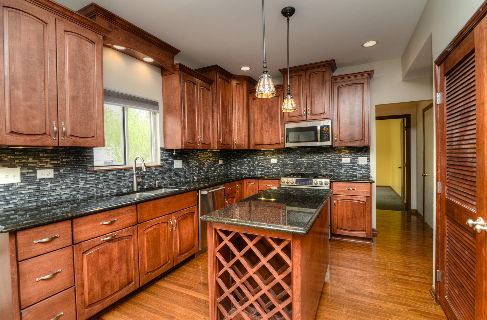 503 Yardley Drive Carol Stream, IL 60188 - Photo 13 of 41 a kitchen with granite countertop wooden cabinets a sink a window and stainless steel appliances