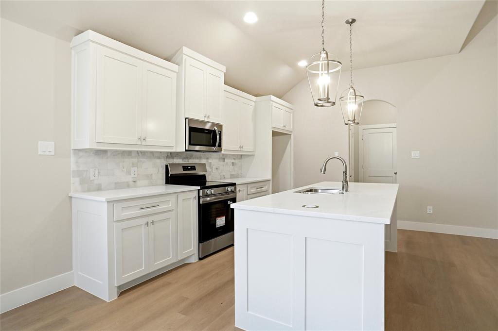 133 Joel Street Springtown, TX 76082 - Photo 4 of 15 a kitchen with a sink stove and microwave