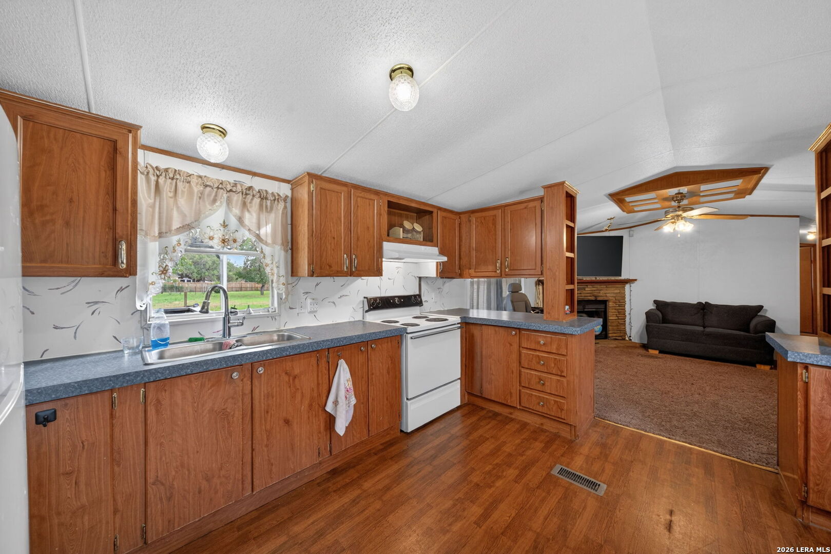 23398 Mathis Road Elmendorf, TX 78112 - Photo 8 of 18 a kitchen with stainless steel appliances granite countertop a sink and wooden cabinets