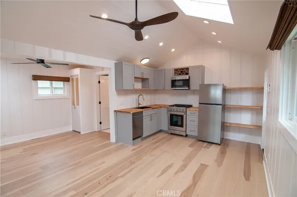 a kitchen with stainless steel appliances granite countertop a refrigerator and a stove top oven