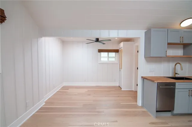 a view of a kitchen with a refrigerator a ceiling fan and wooden floor