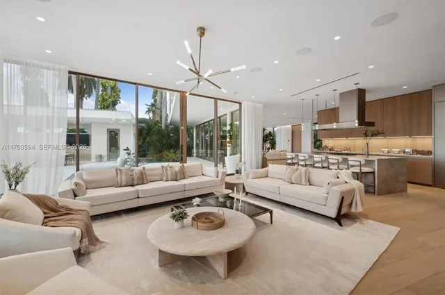 a kitchen with stainless steel appliances kitchen island a table chairs sink and cabinets