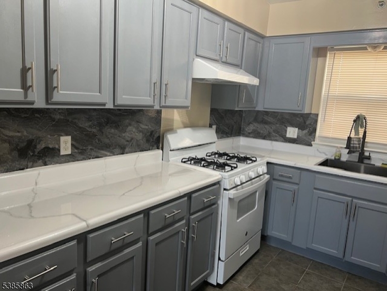 45 2nd Street Newark, NJ 07107 - Photo 11 of 32 a kitchen with granite countertop white cabinets and white appliances