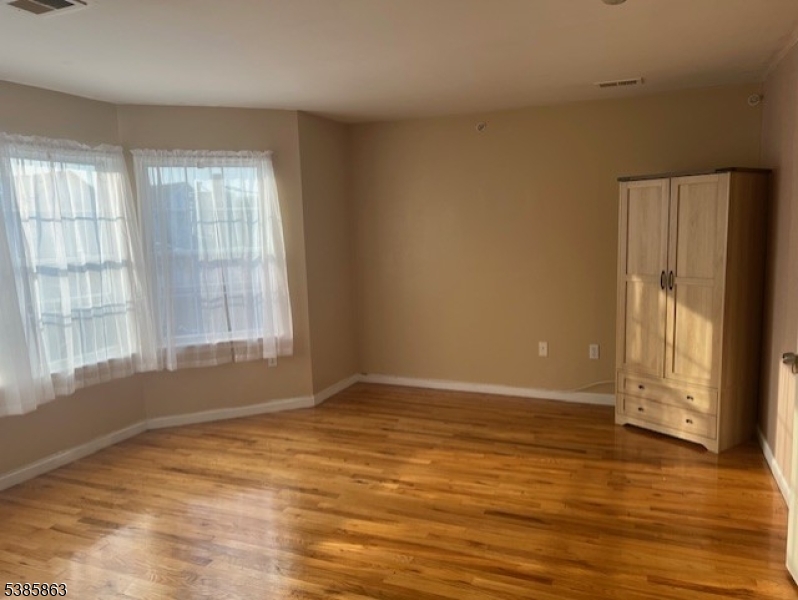 45 2nd Street Newark, NJ 07107 - Photo 2 of 32 a view of an empty room with wooden floor and a window