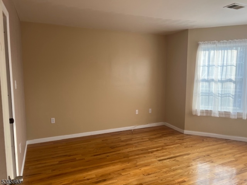 45 2nd Street Newark, NJ 07107 - Photo 5 of 32 a view of an empty room with wooden floor and a window