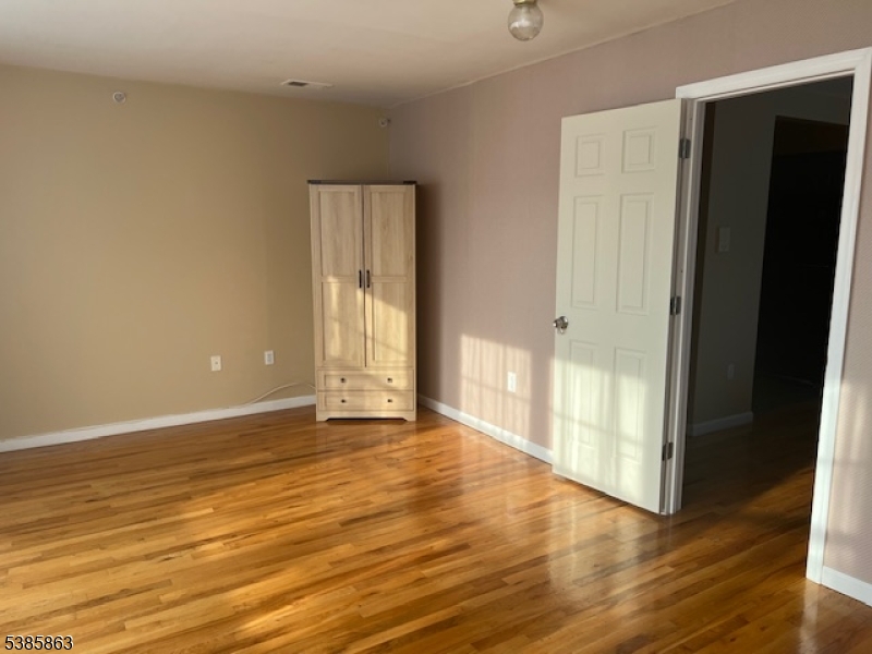 45 2nd Street Newark, NJ 07107 - Photo 6 of 32 a view of an empty room with wooden floor and a window