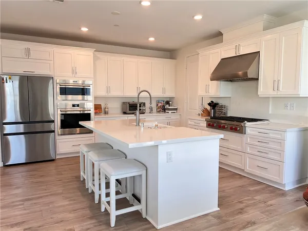 a kitchen with stainless steel appliances a stove a sink a refrigerator and cabinets