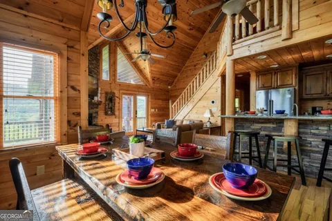 a living room with furniture a fireplace and floor to ceiling windows
