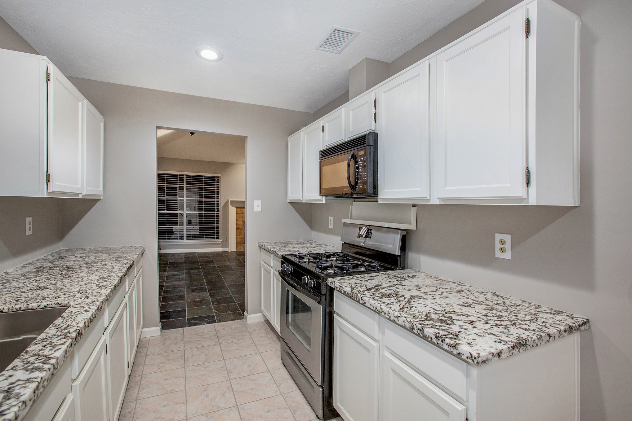a kitchen with stainless steel appliances granite countertop a stove sink and cabinets