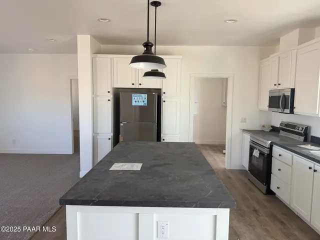 a kitchen with kitchen island sink and refrigerator