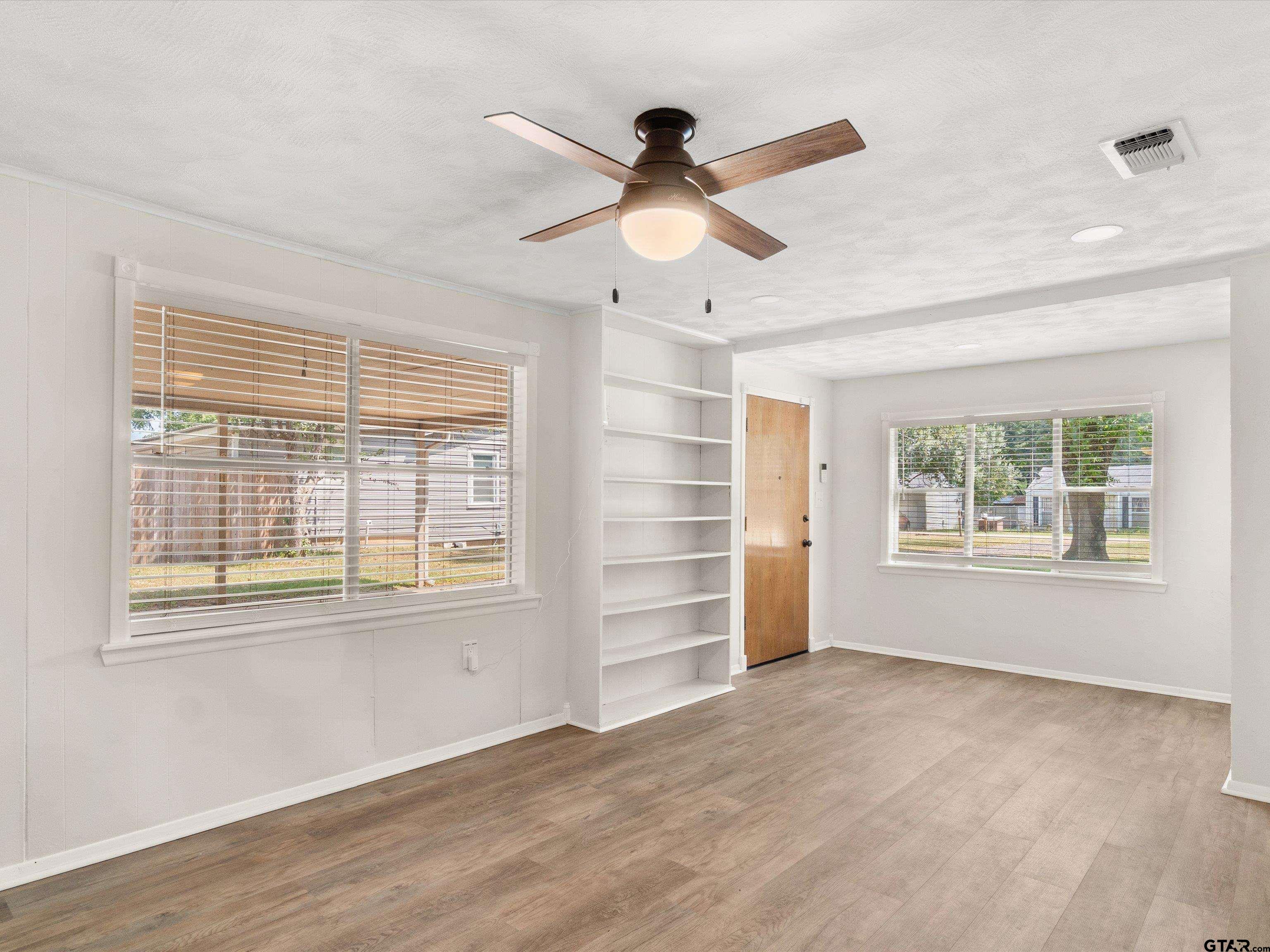 210 Gilbert Street Lone Star, TX 75668 - Photo 21 of 24 a view of an empty room with a window and wooden floor