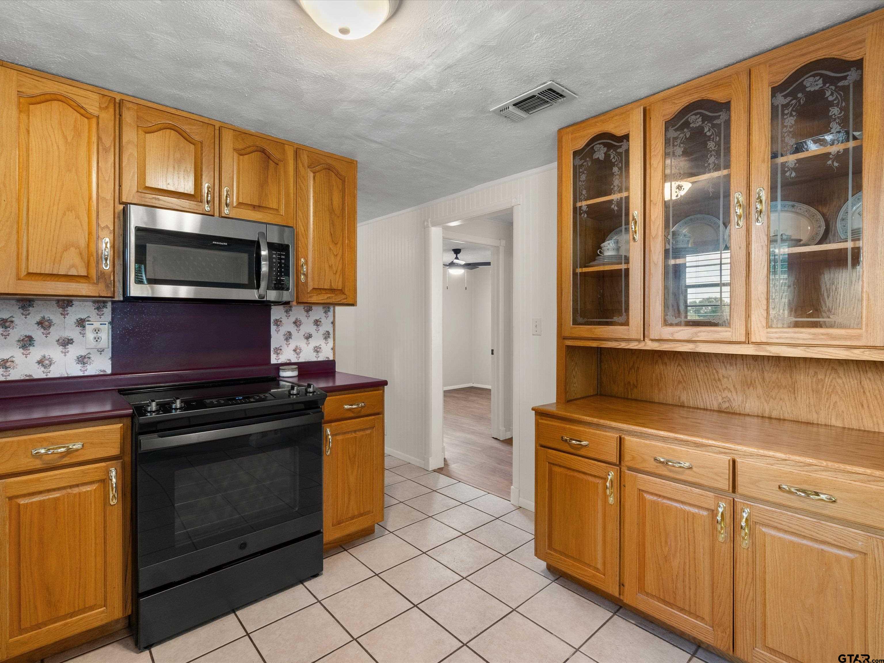 210 Gilbert Street Lone Star, TX 75668 - Photo 4 of 24 a kitchen with stainless steel appliances granite countertop a stove microwave and cabinets