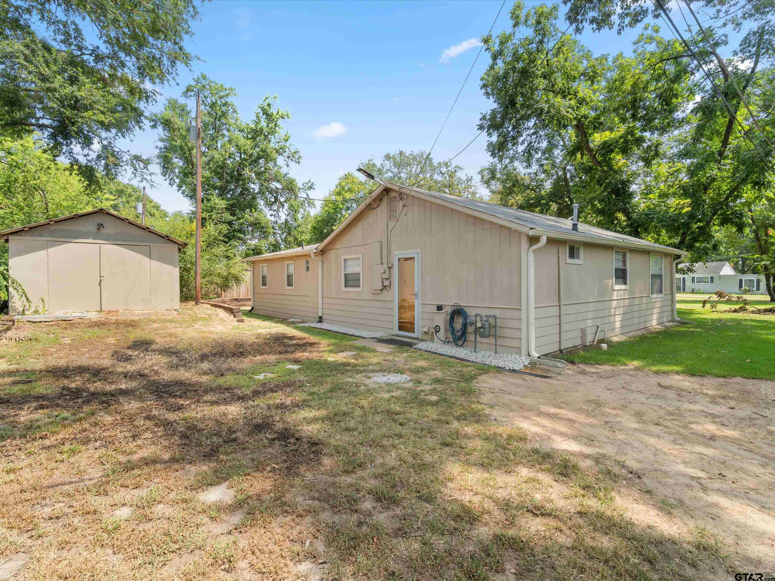 210 Gilbert Street Lone Star, TX 75668 - Photo 6 of 24 a front view of a house with a yard and garage