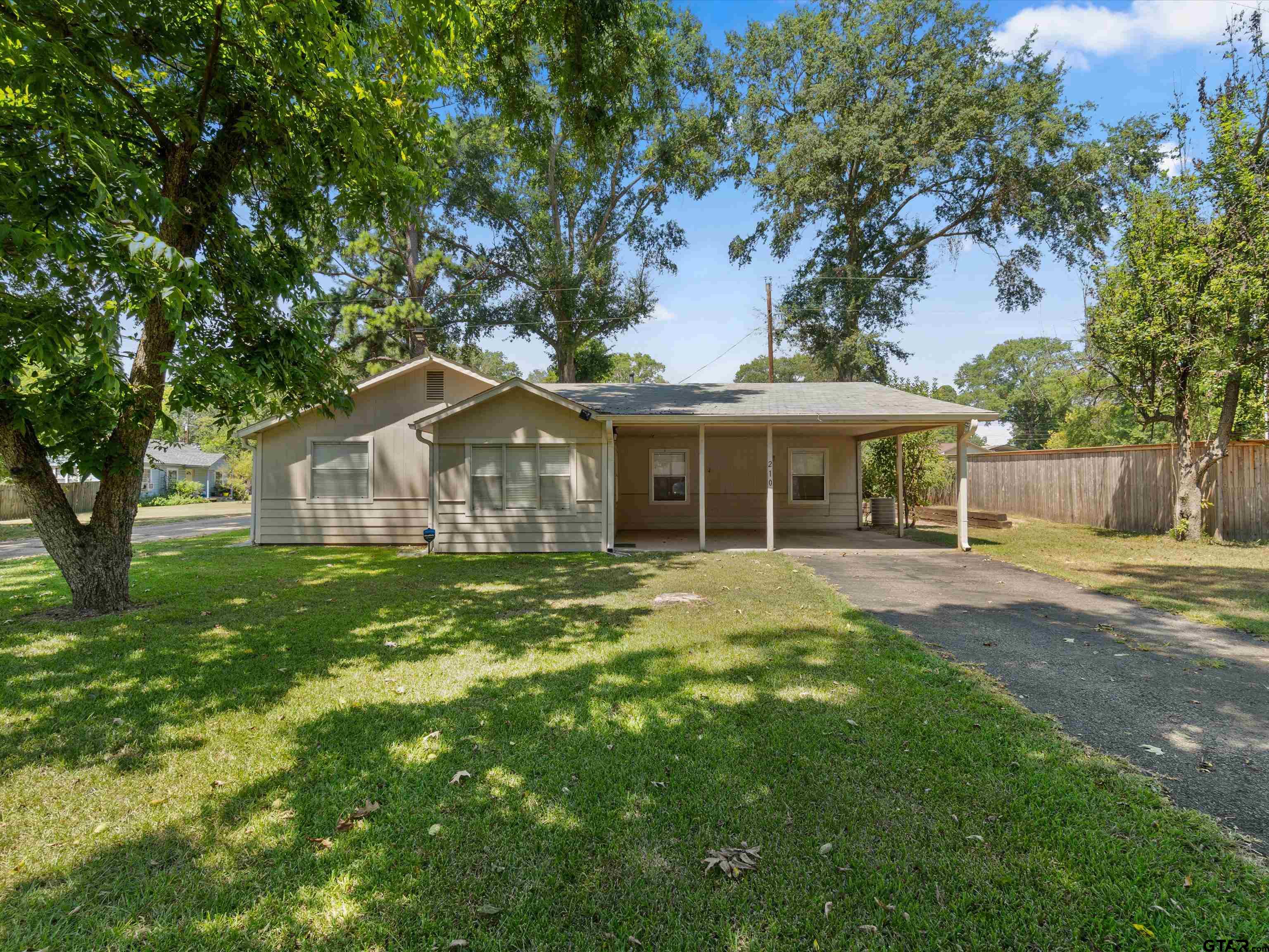 210 Gilbert Street Lone Star, TX 75668 - Photo 7 of 24 a front view of a house with a garden and porch