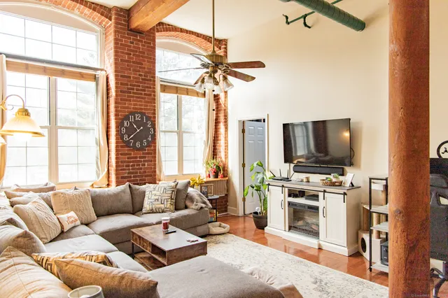 a living room with furniture a flat screen tv and a window