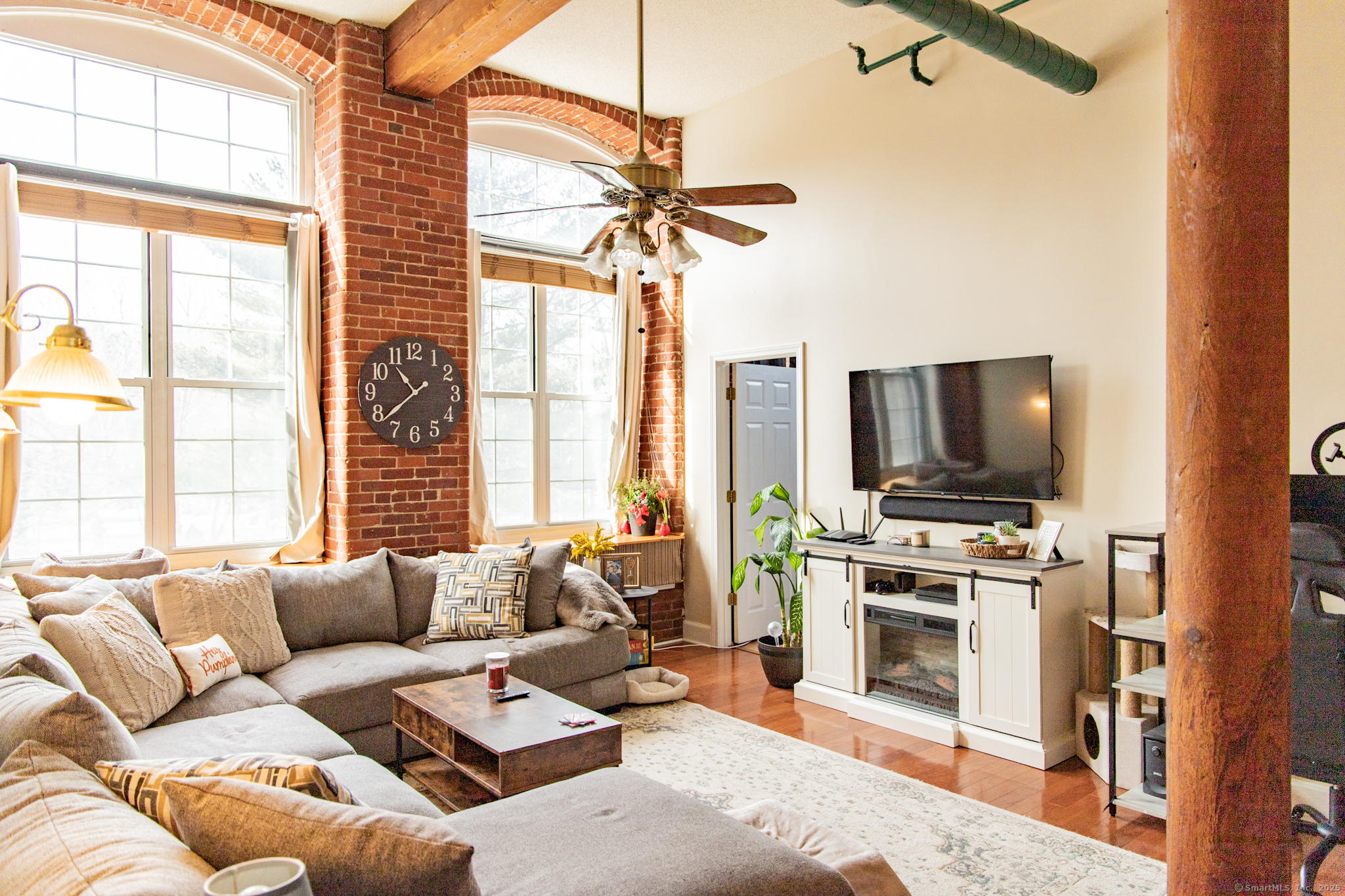 a living room with furniture a flat screen tv and a window