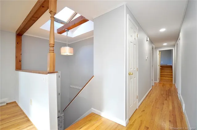 a view of a hallway with wooden floor and staircase
