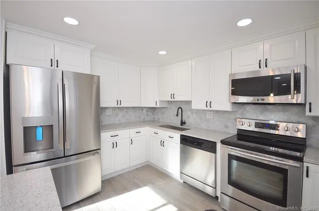 a kitchen with stainless steel appliances a refrigerator sink and microwave